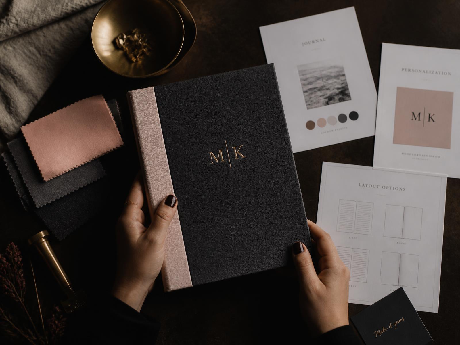 Hands holding a personalized journal beside fabric swatches and layout options