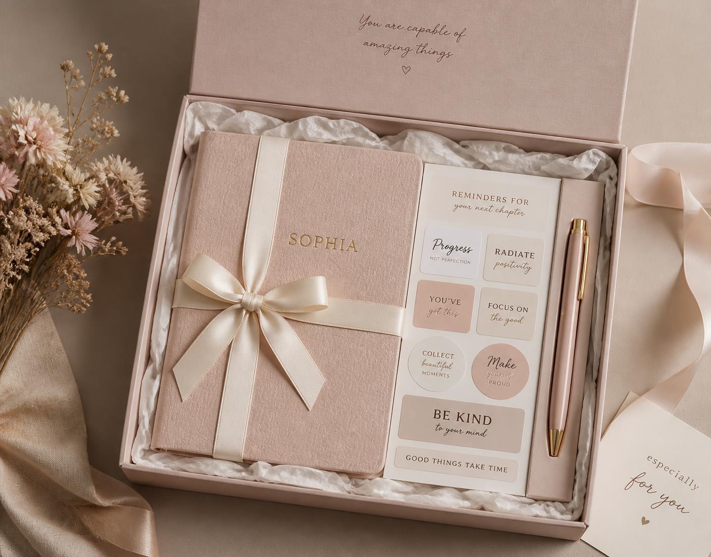 A blush Inklier gift box with a personalized journal, sticker sheet and pen
